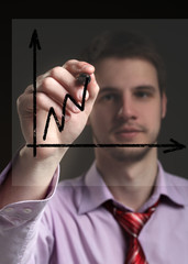 Businessman draws on a transparent screen graphics. Concept - pr