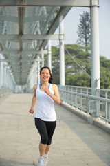 Fototapeta premium fitness woman running at city footbridge