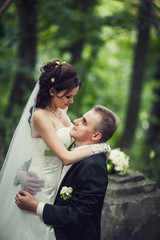 married couple in forest embracing, young groom and bride