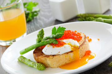 Fresh toast with poached egg, caviar and asparagus.