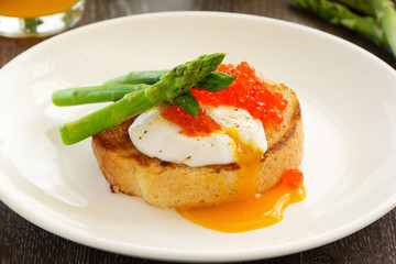 Fresh toast with poached egg, caviar and asparagus.
