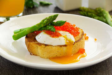 Fresh toast with poached egg, caviar and asparagus.