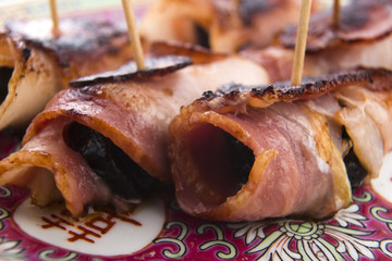 Baked prunes in bacon on a plate