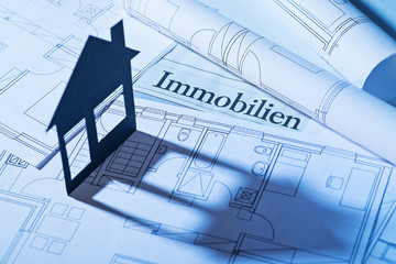 Haus mit Schatten und Bauplänen