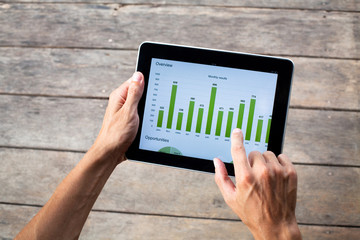 tablet with green chart in hands of business man