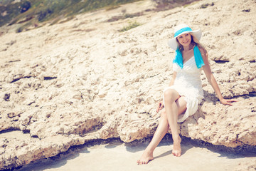 Young beautiful woman on beach in hat