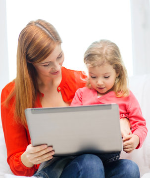 happy mother and daughter with laptop computer