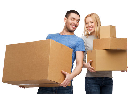 smiling couple holding cardboard boxes