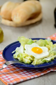 uova al tegamino con contorno d’insalata e cestino del pane