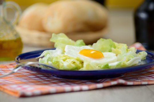 uova al tegamino con contorno d’insalata e cestino del pane