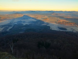 View from peak of conical mountain to morning foggy valley. 