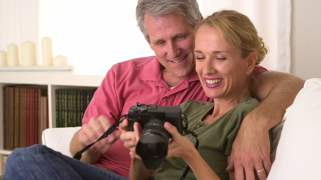 Senior couple looking at pictures on camera