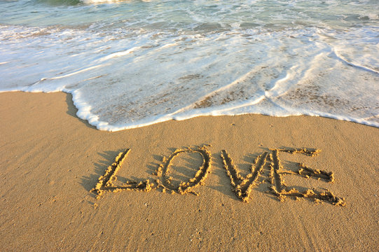word love drawn on beach