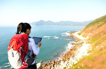 woman hiker seaside use digital tablet