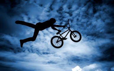 Silhouette of a man with a bmx bike.