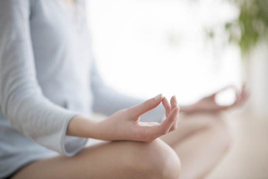 Woman meditating in the lotus position closeup