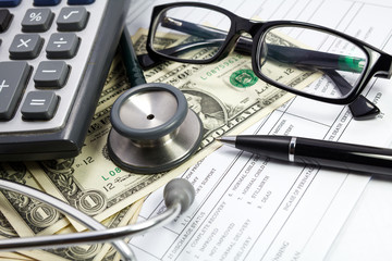 Pen stethoscope glasses and dollar on blank Patient information
