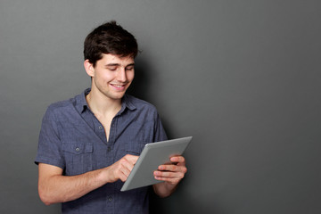young male smiling using digital tablet