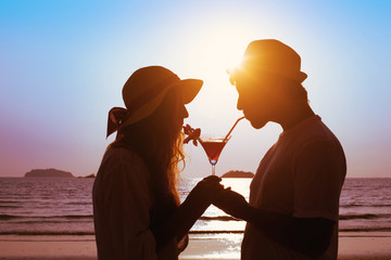 share the pleasure, couple drinking cocktail on the beach