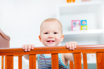 Baby boy standing in crib