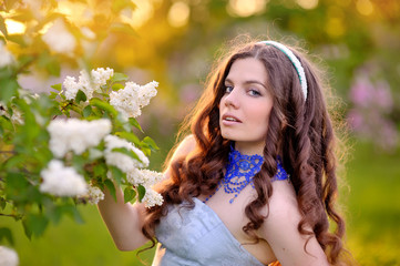 beautiful girl on a background of white flowering trees