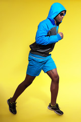 Athletic black man in sportswear fashion. Runner with hoody jack
