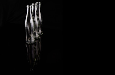 Empty bottles over black background