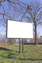 Blank billboard in a park with blue sky