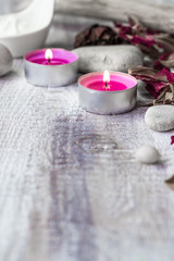 Fototapeta na wymiar Stones candles petals rose wooden background