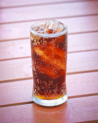 A glass of cola with ice cubes