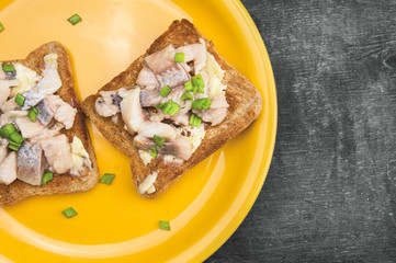 Salt herring sandwiches on old gray wooden table, close-up
