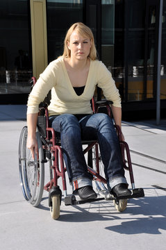 Frau fährt in Rollstuhl