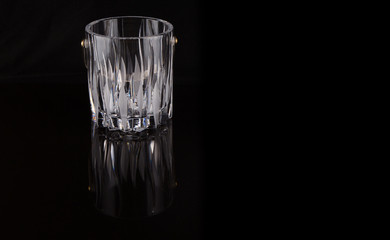 Empty crystal ice bucket over black background