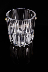 Empty crystal ice bucket over black background