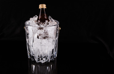 A bottle of refreshing drink chilled in an ice bucket
