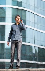 Boy talking on a cell phone in front of the office building