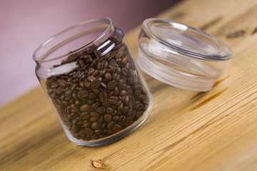 Jar of coffee on wooden table with purple background