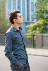 Street portrait of thoughtful boy in front of office building