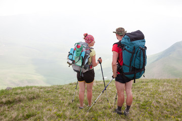 Fototapeta na wymiar Hiker looks for the way in Carpathian mountains standing far abo