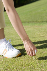 female golfer setting up a tee