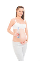 A young pregnant woman holding a bottle of fresh water