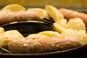 Potato and sausages on the grill
