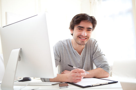 Portrait Of A Young Relaxed Men Writting At The Office