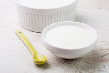 Two white ceramic bowls and a yellow spoon