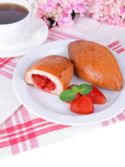 Fresh baked pasties with strawberries on plate on table