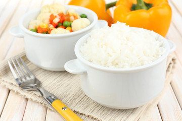 Cooked rice with vegetables on wooden table close up