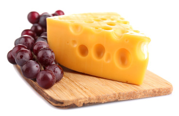 Piece of cheese and grape on wooden board, isolated on white