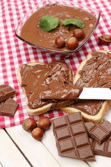 Bread with sweet chocolate hazelnut spread on wooden background