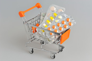 Shopping cart with medical supplies on gray
