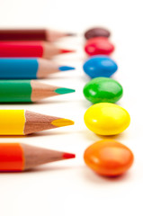 Closeup photo of pencils pointing at the same color candies